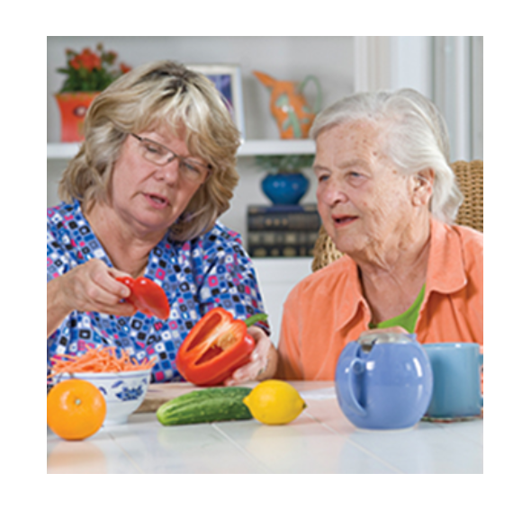 Two women peeling veggies